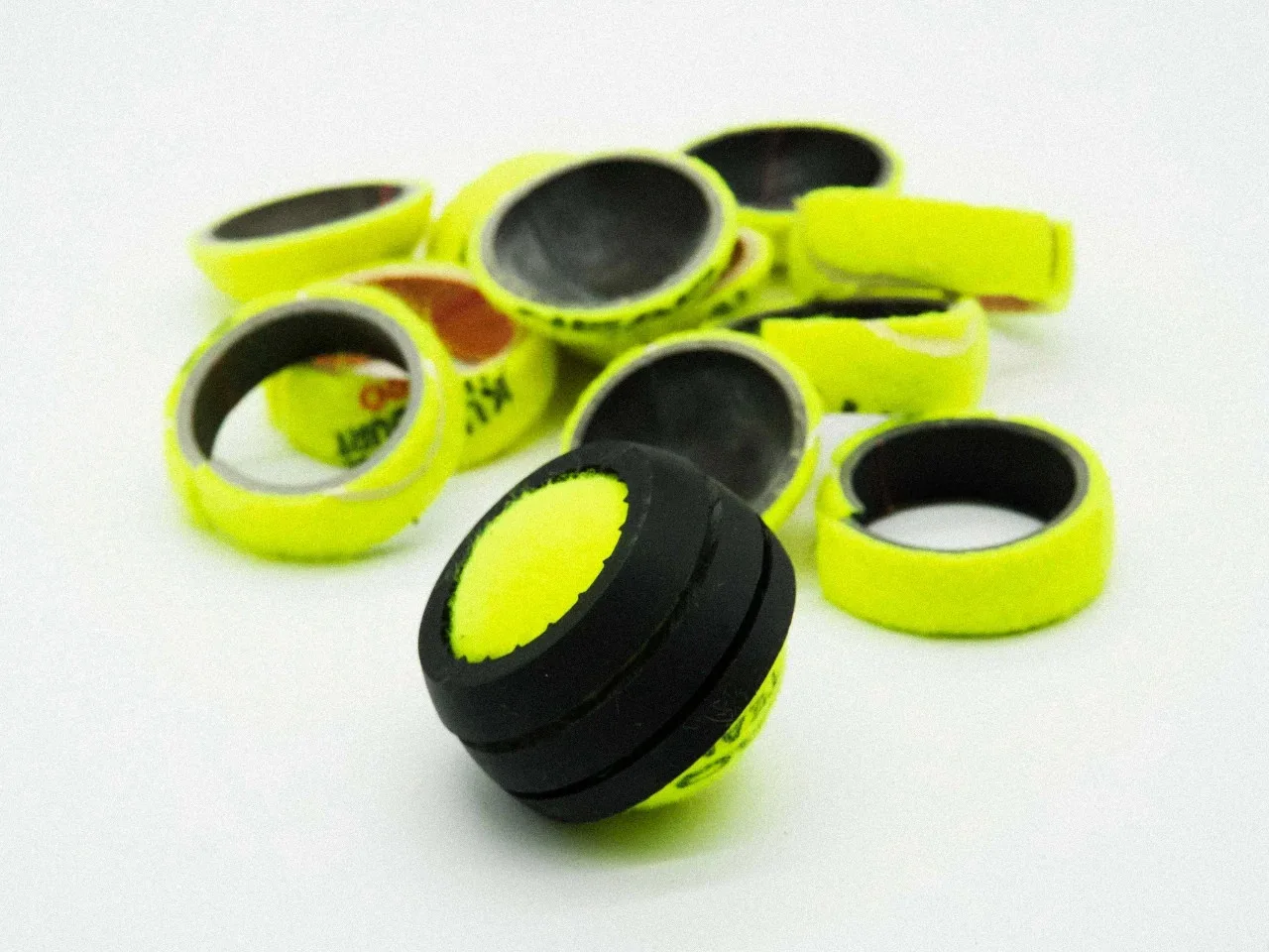 Pile of old, used tennis balls ready to be recycled into footwear.