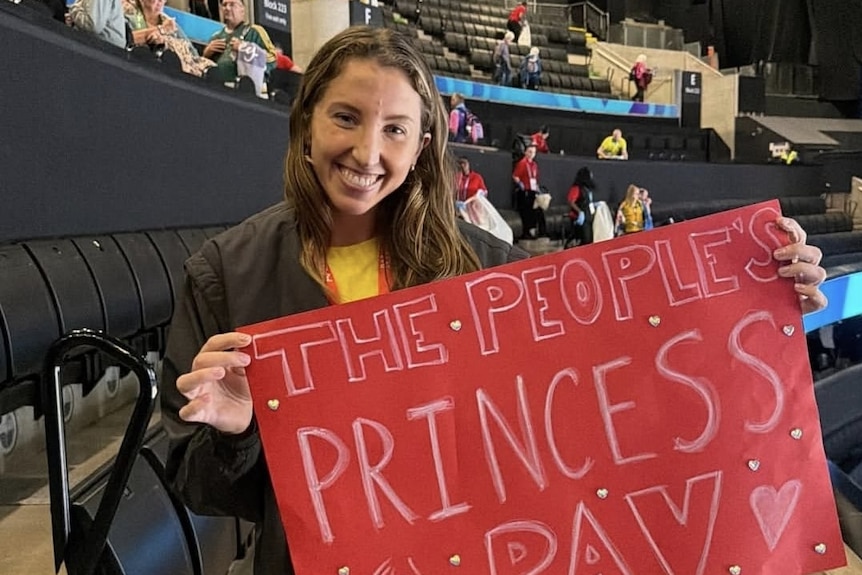 Amy Parmenter with her sign supporting Uneeq Palavi at at Australia's Commonwealth Games opening netball game against Tonga.