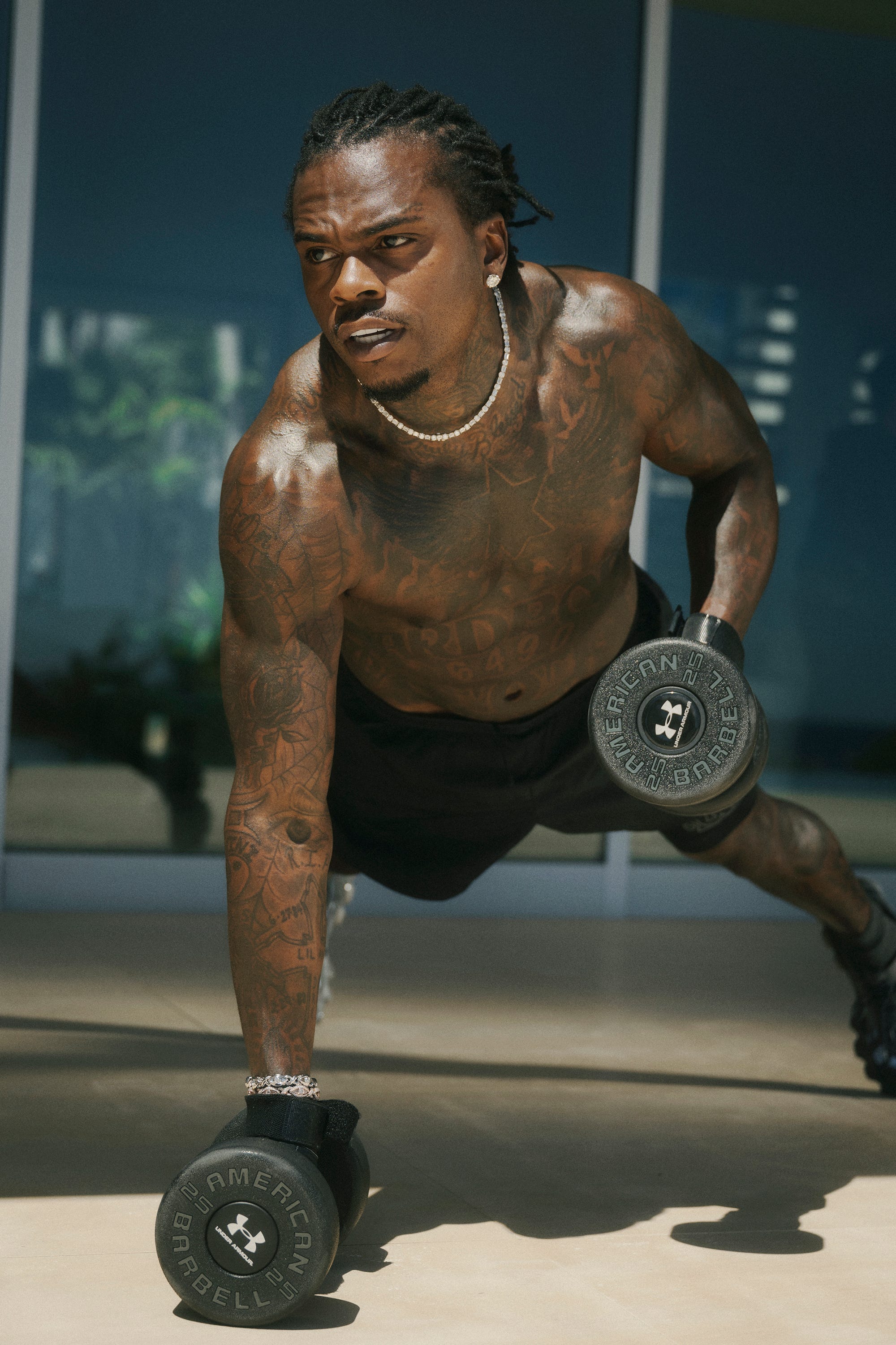 Athletic individual performing a workout with dumbbells in a bright indoor environment.