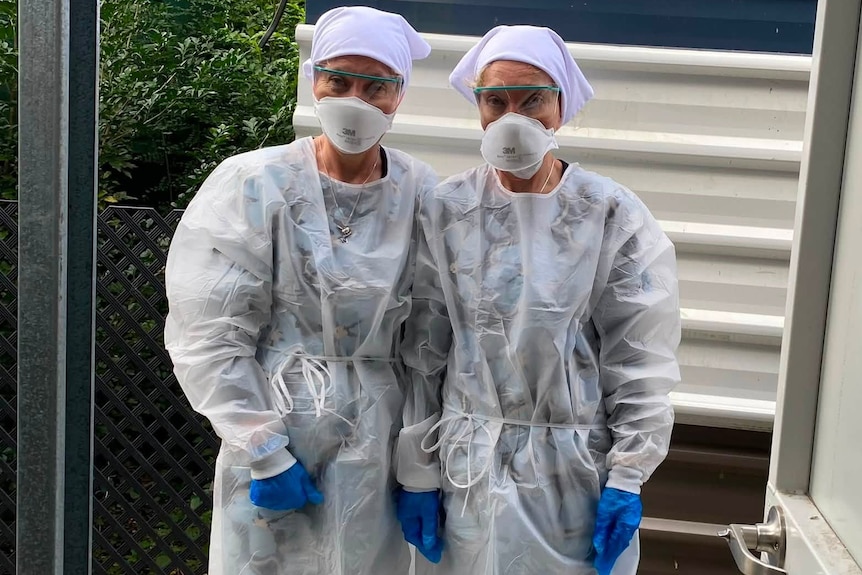 Women in protective masks and clothes.