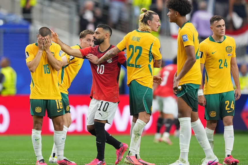 Mo Salah pats a disappointed Aziz Behich on the head