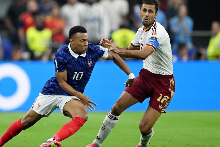 Kylian Mbappe and Rodri compete for the ball