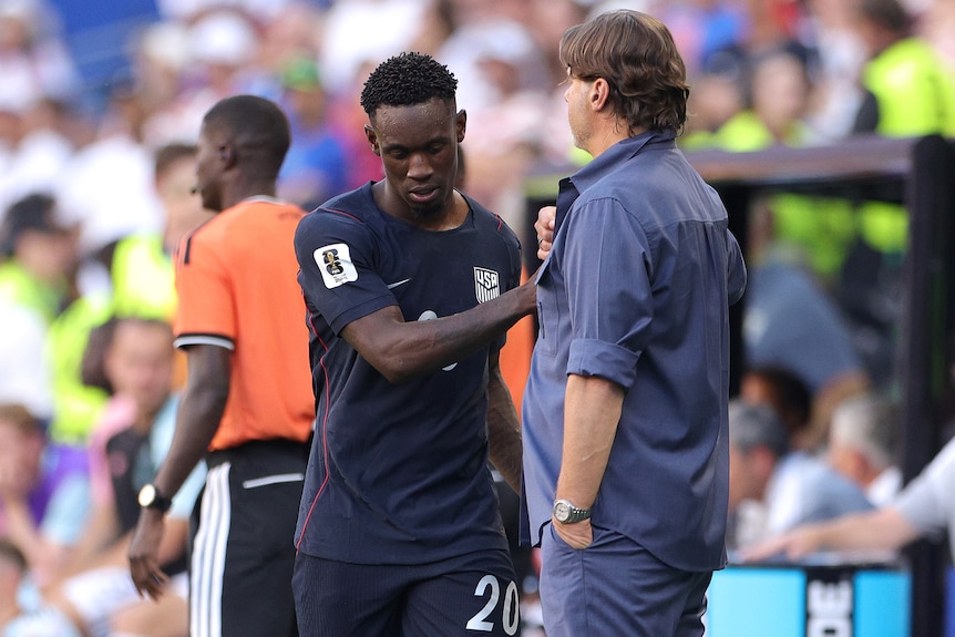 Folarin Balogun of United States shakes hands with coach Mauricio Pochettino.