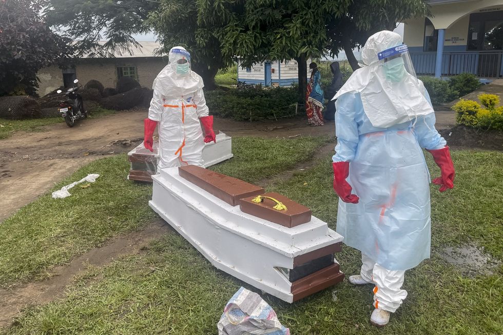 Ebola healthcare workers next to coffin
