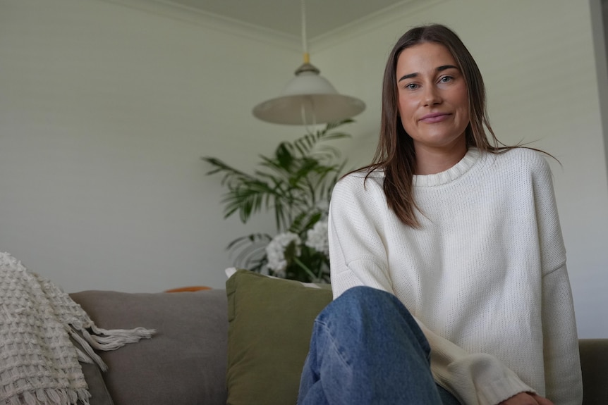a woman sitting on a couch in a home