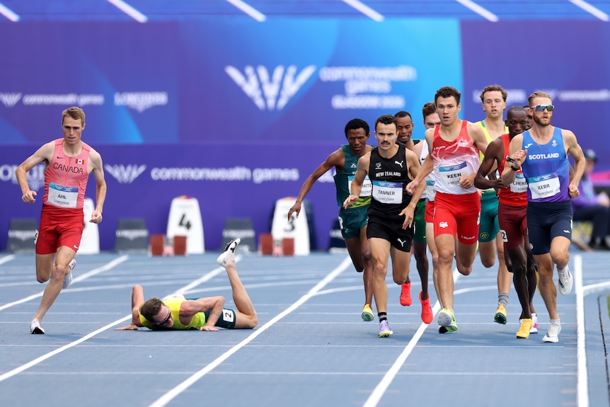 Ollie Hoare lies on the track as other runners veer around him.