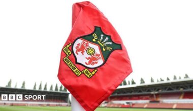 Red corner flag with Wrexham logo inside the Racecourse Ground