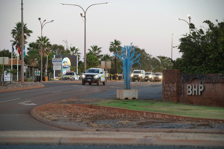 A road intersection with BHP sign on right and car on road on left