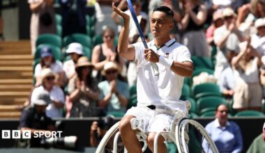 Tokito Oda raises his racquet in celebration of winning a point