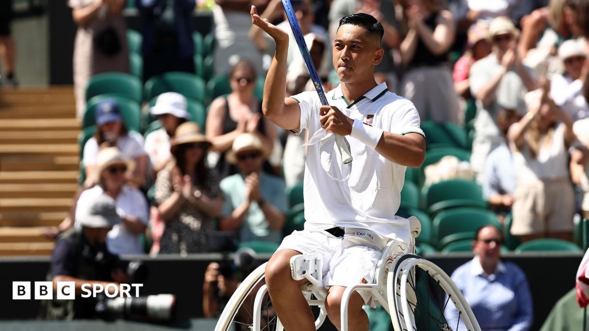 Tokito Oda raises his racquet in celebration of winning a point
