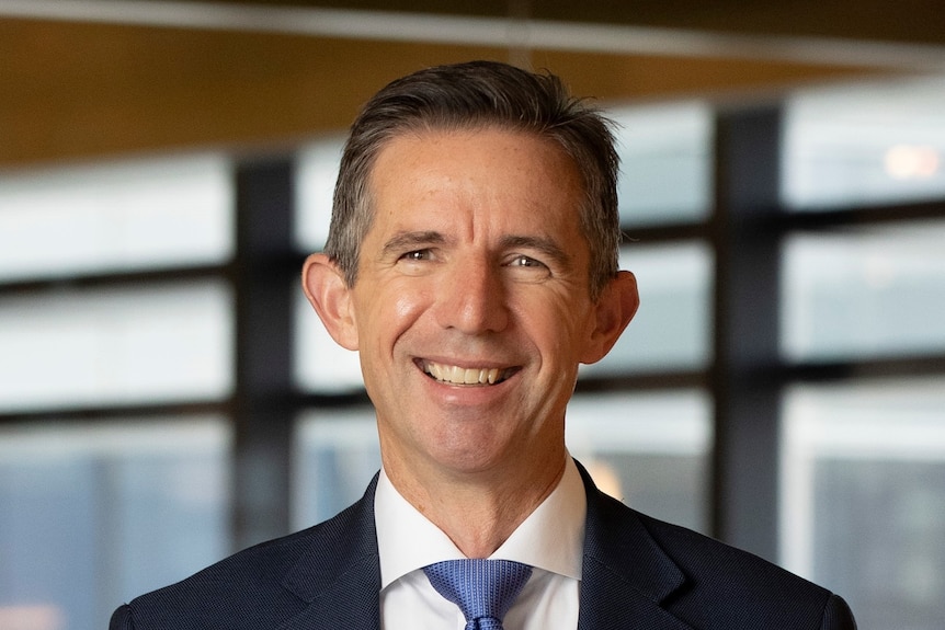 Simon Birmingham smiles at the camera wearing a suit.