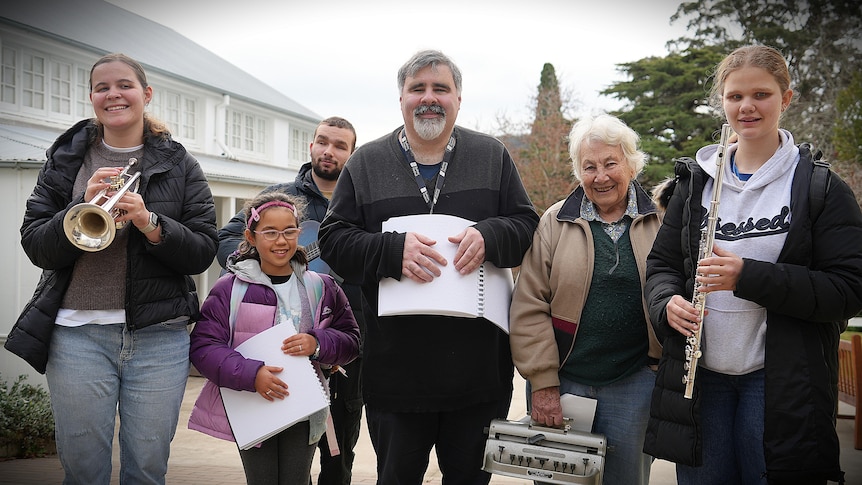 Group of people, children and adults, holding musical instruments