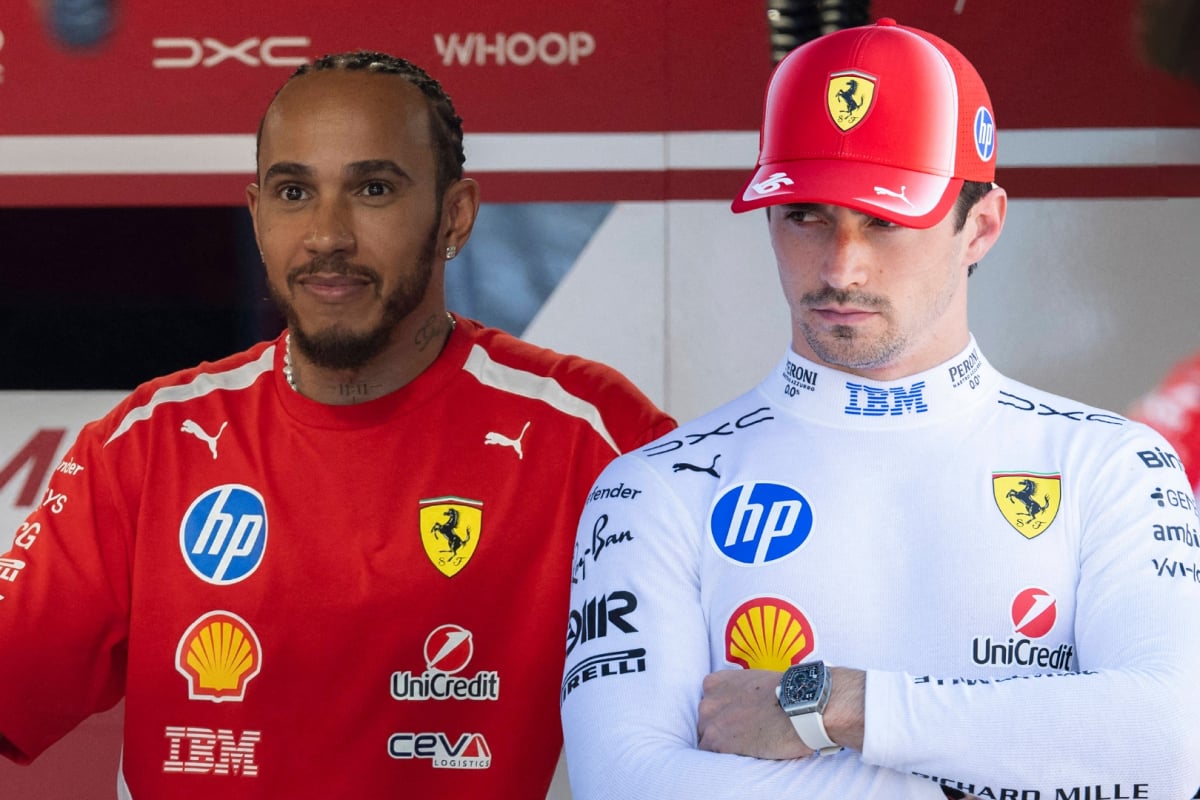 Hamilton smiling with grumpy Leclerc edited next to him in white Ferrari kit holding F1 microphone