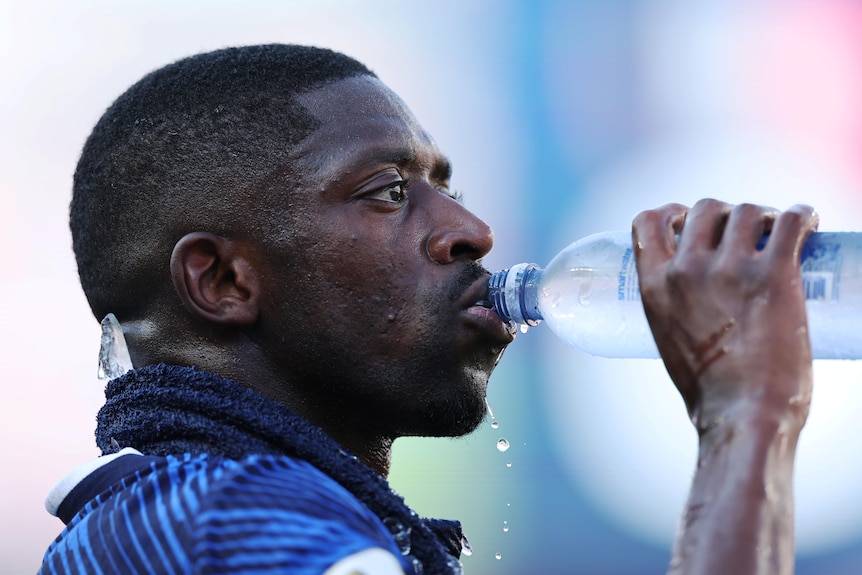 Ousmane Dembélé drinks water with ice around his neck