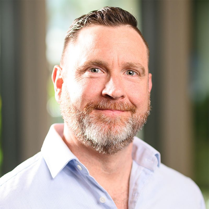 A man with a beard smiles at the camera.