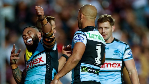 Cronulla players celebrate after scoring a try.