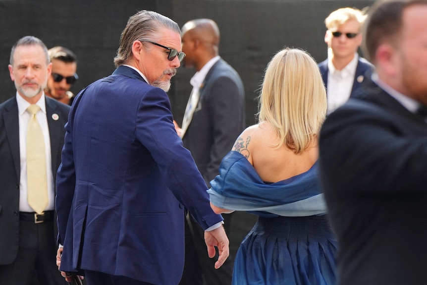 A man with sunnies and a suit.