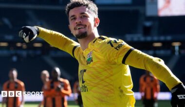 Cieran Slicker celebrates with Barnet fans after a match wearing a yellow goalkeeper jersey