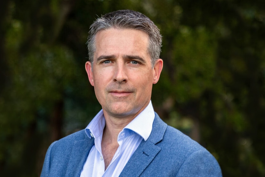 Man with grey hair wearing blue suit