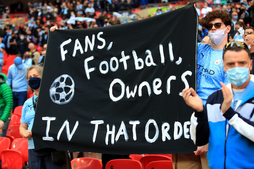 Soccer fans hold up protest banners