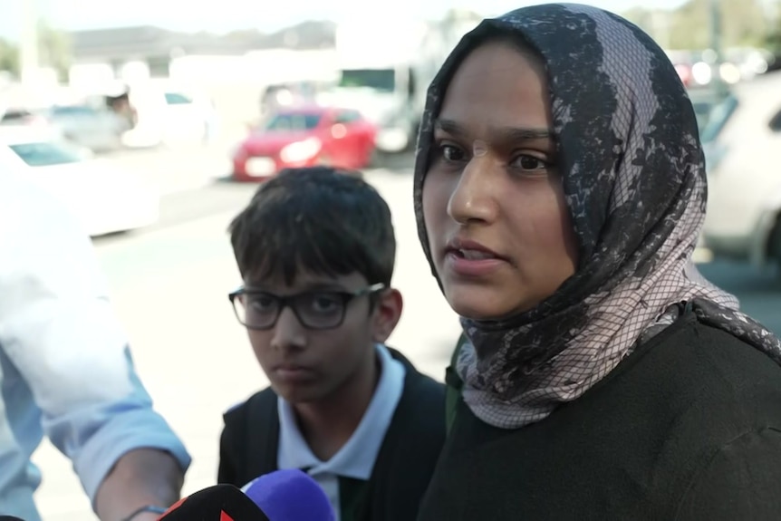 A woman in a hijab speaking to news reporters.
