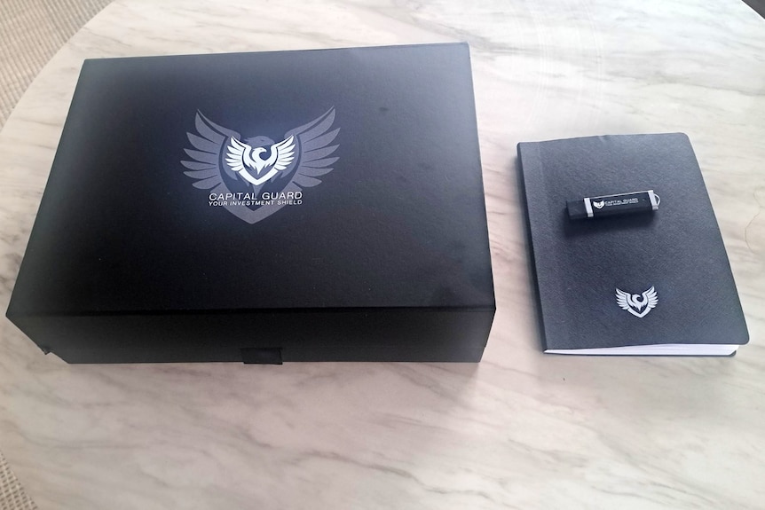 A box and notebook with the Capital Guard branding