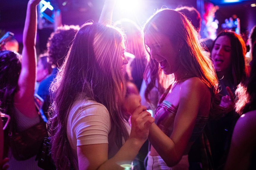 Two young women smiling and dancing.