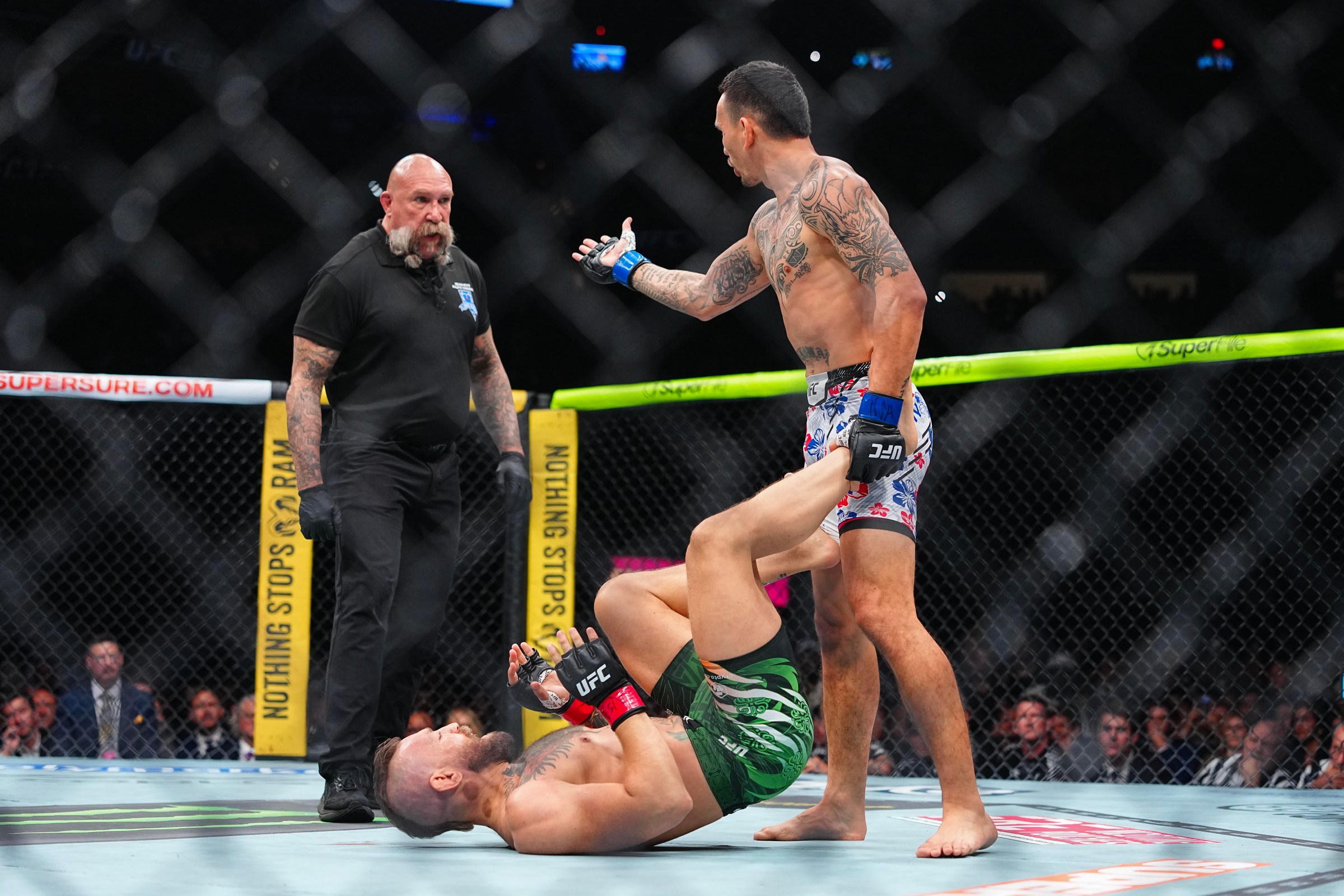 LAS VEGAS, NEVADA - JULY 11: (R-L) Max Holloway speaks to referee Mike Beltran while Conor McGregor of Ireland defends his position in a welterweight fight during the UFC 329 event at T-Mobile Arena on July 11, 2026 in Las Vegas, Nevada. (Photo by Chris Unger/Zuffa LLC)