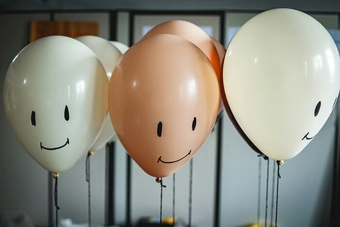 Several balloons with smiley faces, representing stories from hospital employees.