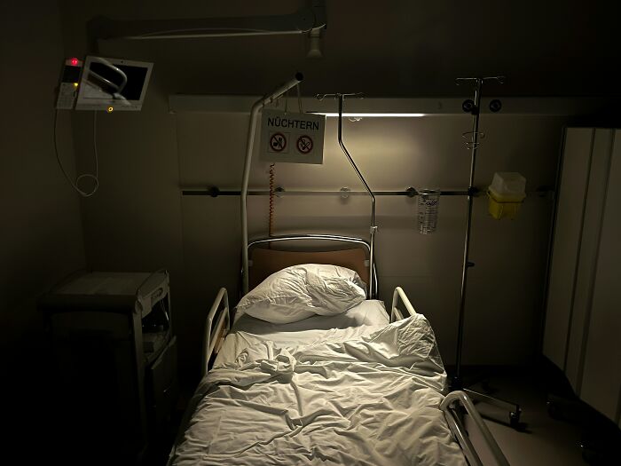 A dimly lit, empty hospital room with a bed, evoking the eerie atmosphere of hospital horror stories.