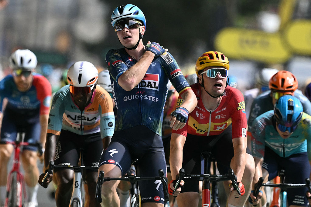 Soudal Quick-Step team's Belgian rider Tim Merlier cycles to the finish line to win the 7th stage ahead of Uno-X Mobility team's Norwegian rider Soren Waerenskjold (R) and NSN Cycling Team's Eritrean rider Biniam Girmay (L) during the 113th edition of the Tour de France cycling race, 175 km between Hagetmau and Bordeaux in southwestern France, on July 10, 2026. (Photo by Jeff PACHOUD / AFP)