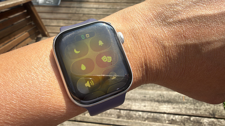 A wrist with an Apple Watch Series 11 showing the water lock icon.
