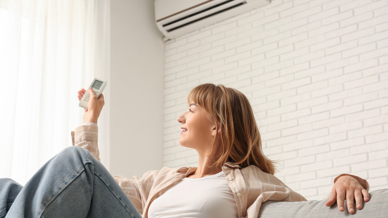 A woman on a couch near an air conditioner