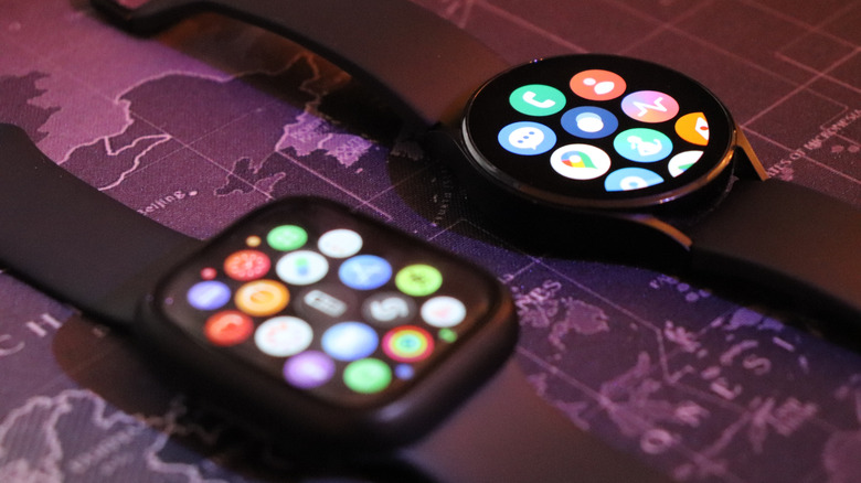 An Apple Watch and Samsung Galaxy Watch lying next to each other