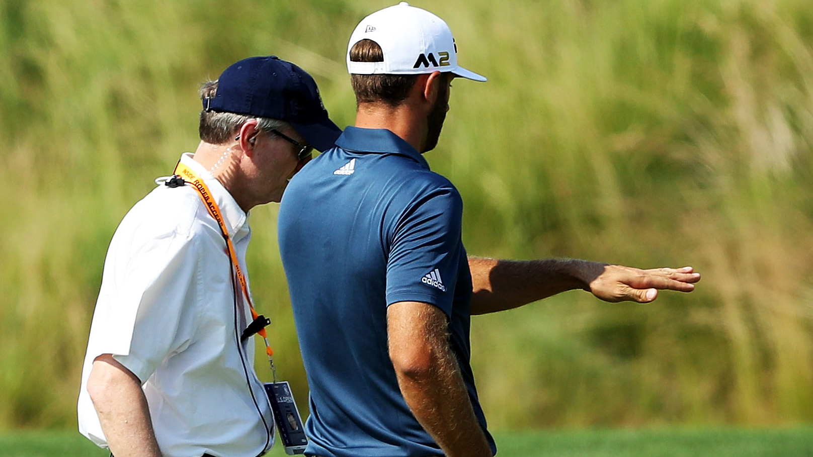 Dustin Johnson speaks to a rules official at the 2016 Masters