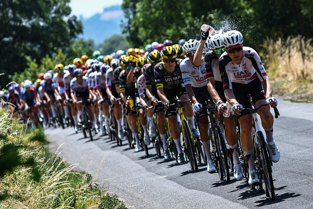 The pack of riders (peloton) cycle in the heat during the 10th stage of the 113th edition of the Tour de France cycling race, 166,6 km between Aurillac and Le Lioran in the Massif Central, on July 14, 2026. (Photo by Anne-Christine POUJOULAT / AFP)