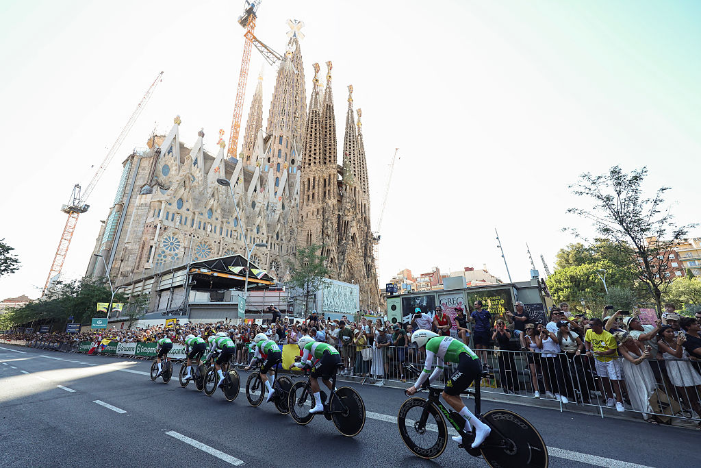 Caja Rural-Seguros RGA team riders cycle past the Sagrada Familia Basilica during the 1st stage of the 113th edition of the Tour de France cycling race, a 19,6 km team time trial stage in and around Barcelona in northeastern Spain, on July 4, 2026. (Photo by Josep LAGO / AFP)