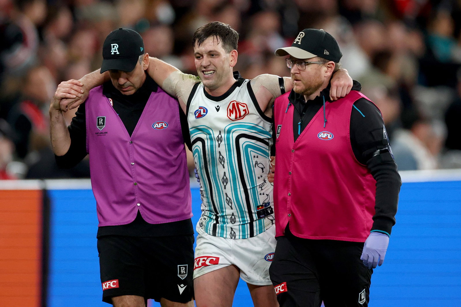 Zak Butters of the Power is assisted from the field during the round 18 AFL match between St Kilda Saints and Port Adelaide Power at Docklands on July 11, 2026, in Melbourne, Australia.