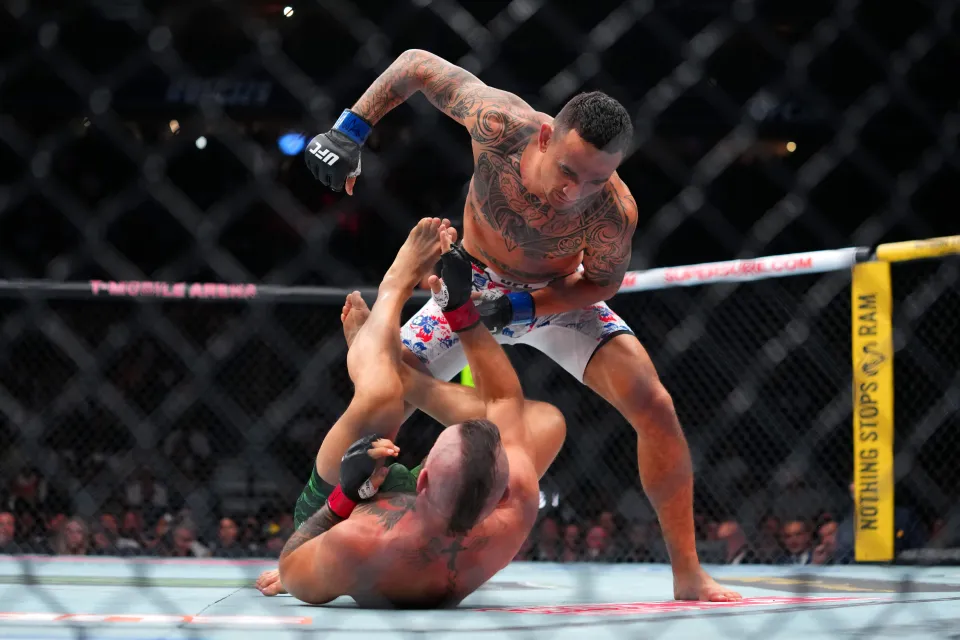 Max Holloway punches Conor McGregor of Ireland in a welterweight fight during the UFC 329 event at T-Mobile Arena on July 11, 2026 in Las Vegas, Nevada