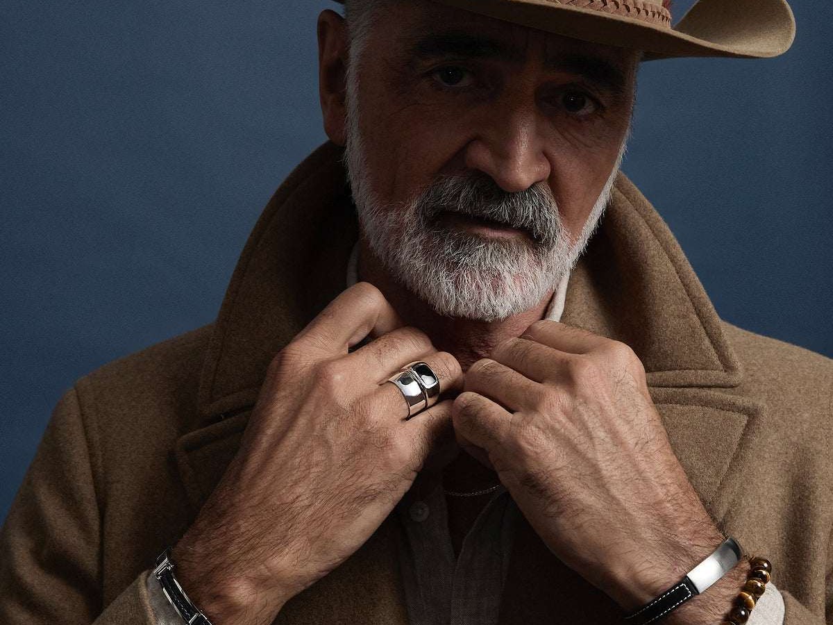 Man in a wool coat wearing a NAJO silver ring, leather bracelet and beaded bracelet