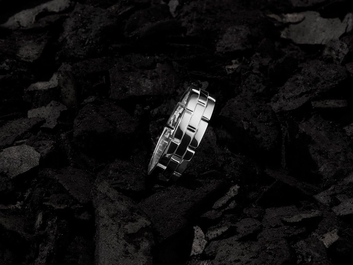NAJO Bastion sterling silver men's ring resting on charcoal