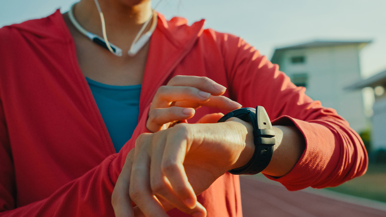 Closeup of a person checking a smartwatch while working out outdoors