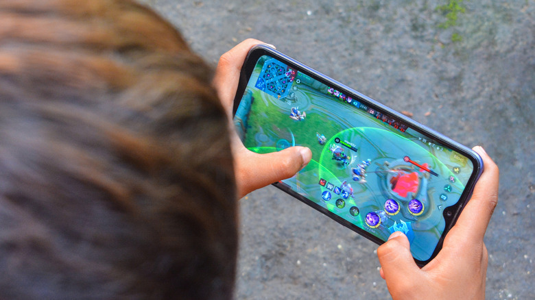 A person playing Mobile Legends on a phone.