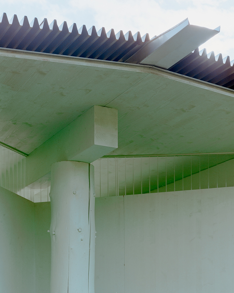 sliding timber frames and reused materials shape reversible pavilion within swiss meadow - 6