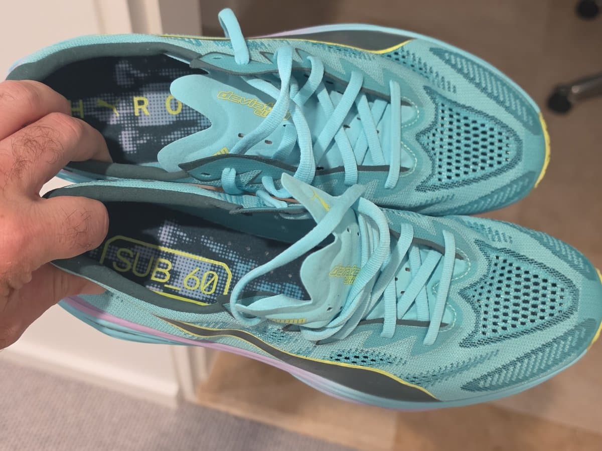 PUMA x HYROX Deviate NITRO Elite shoes held in hand showing the Sub 60 insoles
