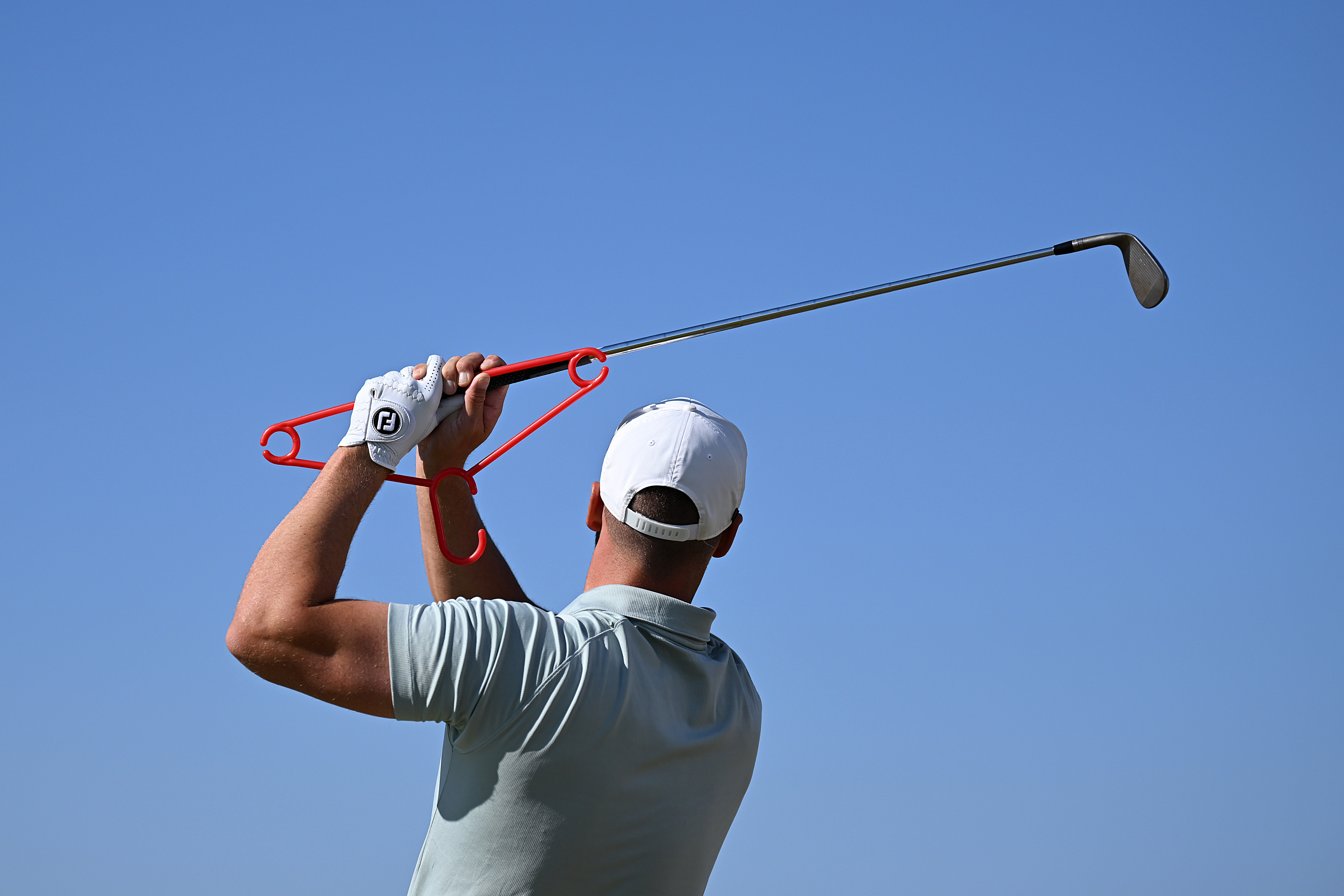 Wyndham Clark of the United States warms up using a coat hanger on the practice rage ahead of a practice round prior to The 154th Open Championship at Royal Birkdale