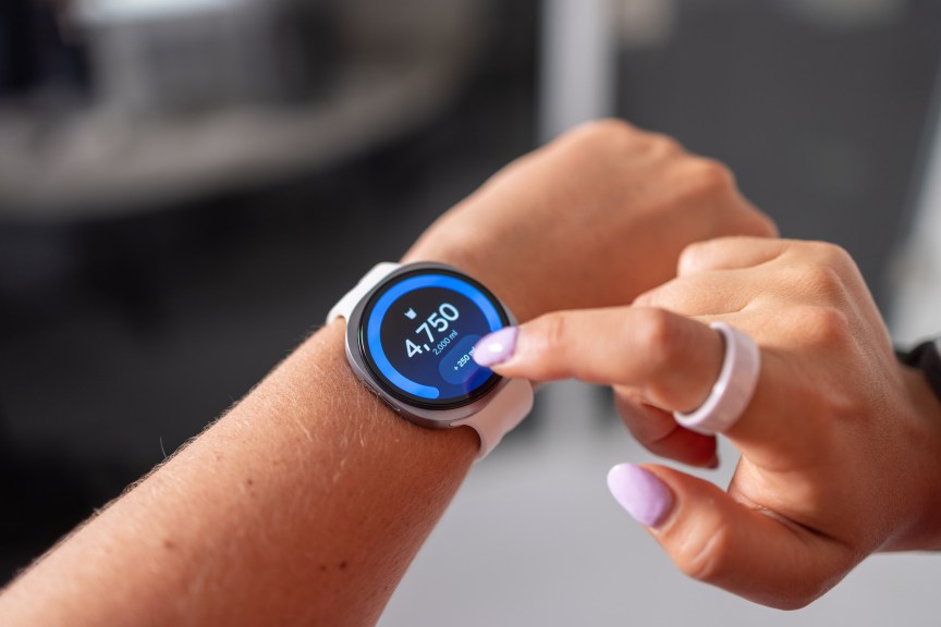 A person taps a button on the screen of the galaxy watch 8 ultra they are wearing.