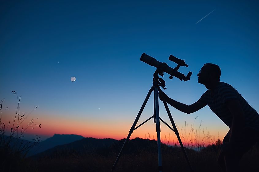 Astronomer looking at the night sky through a telescope.