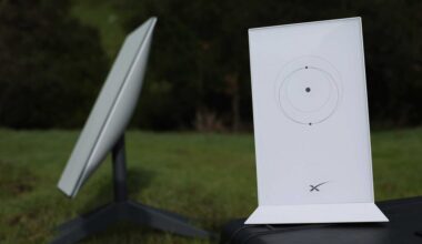 Picture of a Starlink satellite dish and router placed outside, on a lawn.