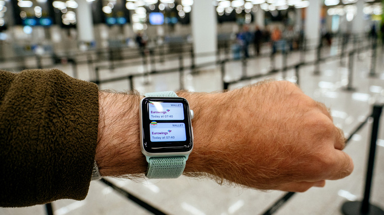 A person with boarding passes shown in their Apple Watch.